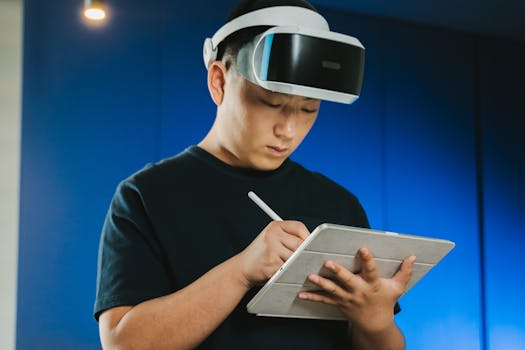 Asian man with virtual reality headset using a tablet indoors, focused and engaged.