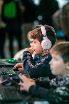 Children engaged in gaming at a computer event, showcasing teamwork and focus.