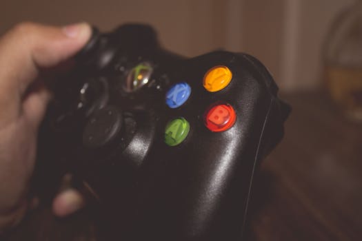 Close-up image of a hand holding a gaming controller with colorful buttons.