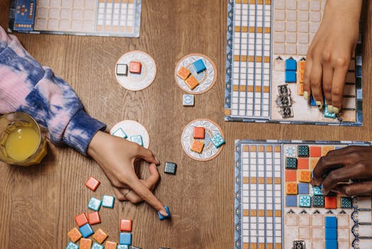 People enjoying a strategic board game on a wooden table with drinks, showcasing social interaction.